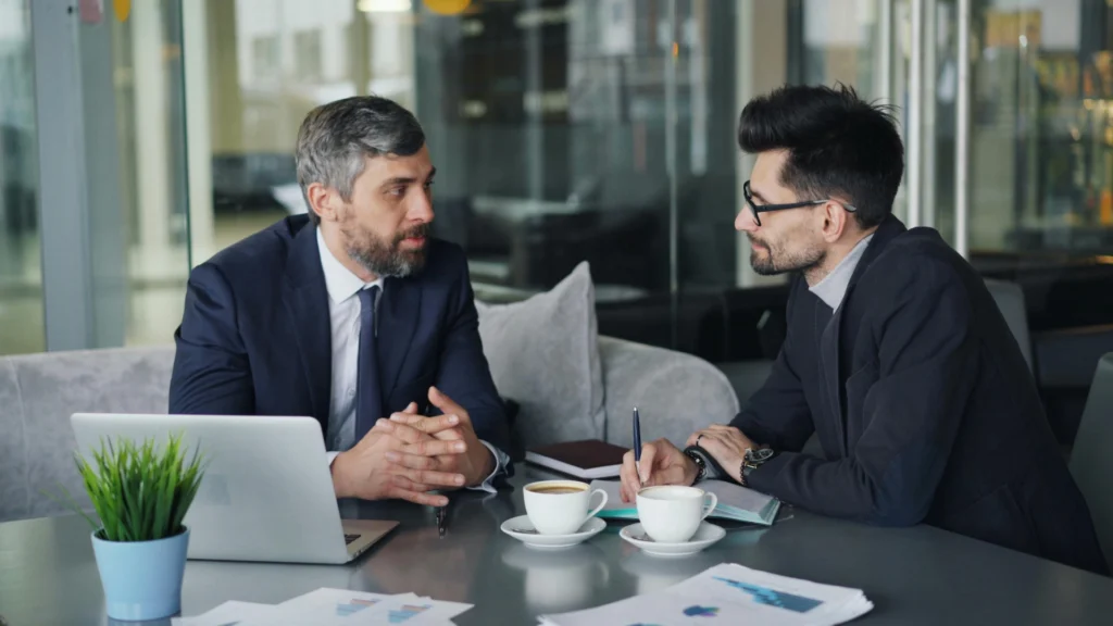 Two business professionals sitting and discussing work.